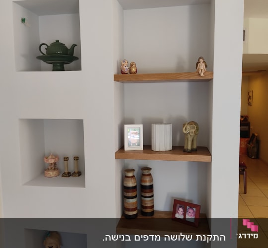 מדף עץ מובנה בקיר עם חפצי נוי